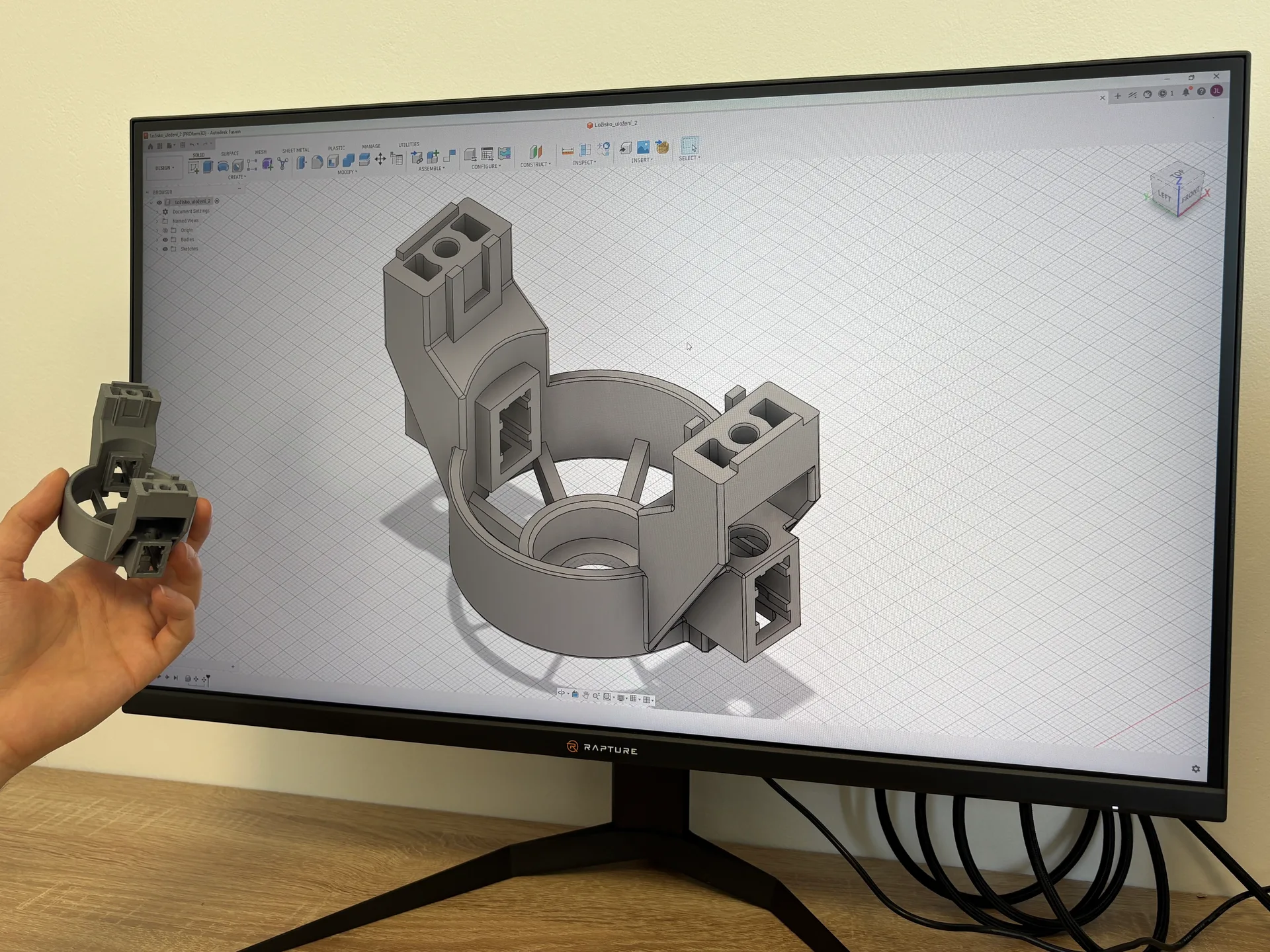 A 3D model on screen next to the finished print